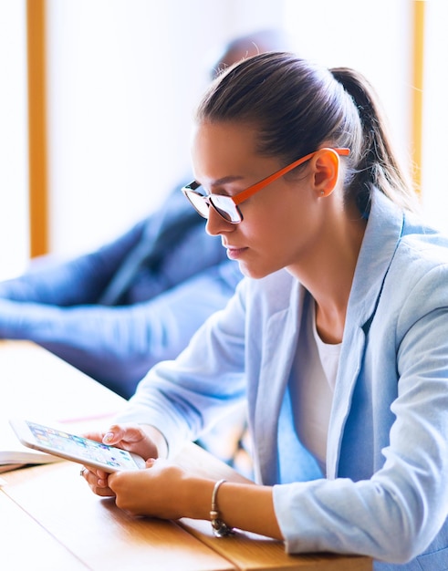 Femme d'affaires assis dans son bureau à l'aide d'une tablette