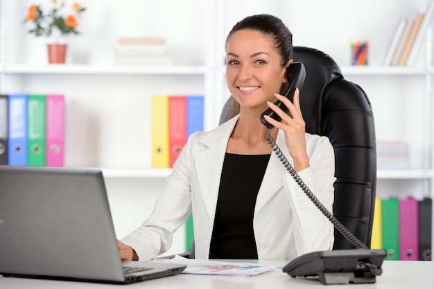 Femme d'affaires assis sur son lieu de travail.