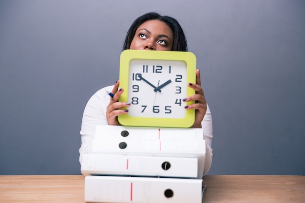 femme d & # 39; affaires assis à la table avec horloge