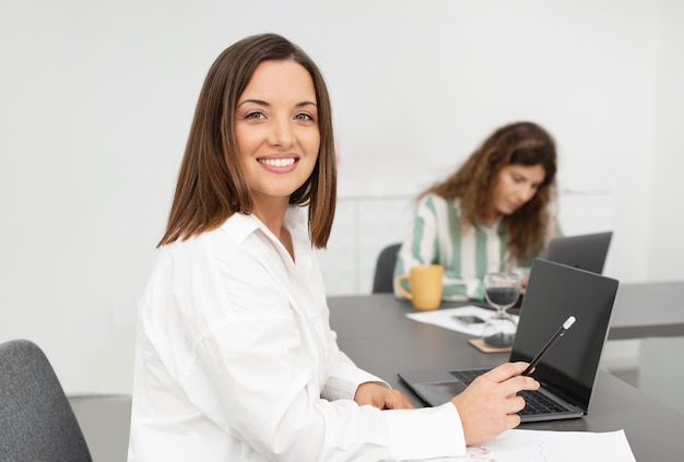 Femme d'affaires assise au bureau travaillant dans un bureau moderne avec un collègue