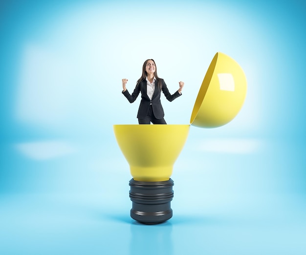 Une femme d'affaires assise dans une lampe jaune dans un intérieur bleu Succès et concept de démarrage