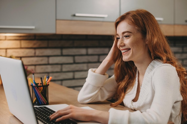 Femme d'affaires assise devant un ordinateur portable et femme d'affaires de technologie d'affaires souriante