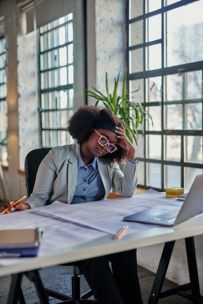 Femme d'affaires assise sur le lieu de travail au bureau et travaillant