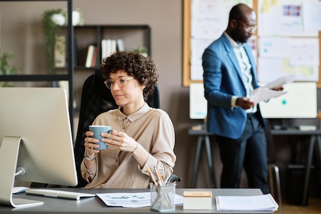 Photo femme d'affaires assise sur son lieu de travail au bureau