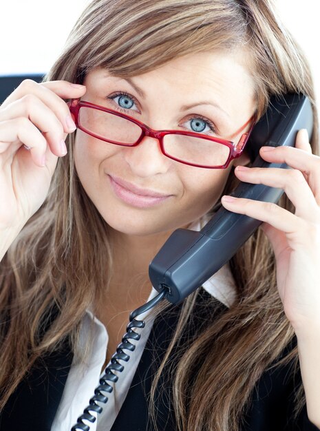 Femme d&#39;affaires attrayant sur le téléphone portant des lunettes rouges