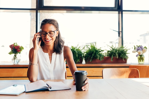 Photo une femme d'affaires au téléphone au bureau.