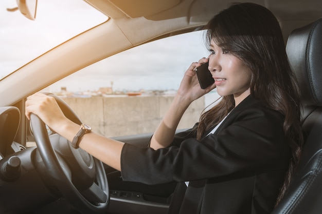 Femme d'affaires au téléphone dans sa voiture.