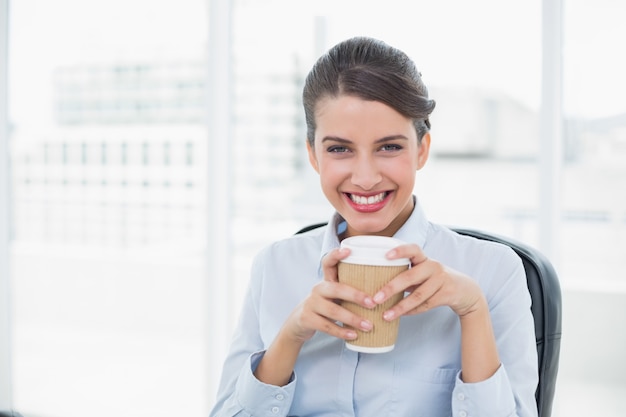 Femme d&#39;affaires aux cheveux bruns élégants bénéficiant d&#39;un café