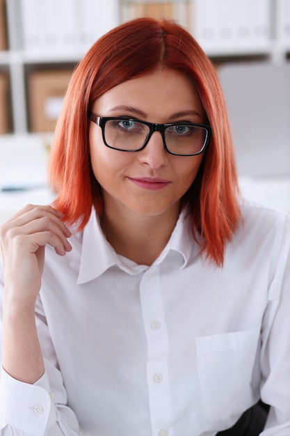 Femme d'affaires aux cheveux rouges avec des lunettes