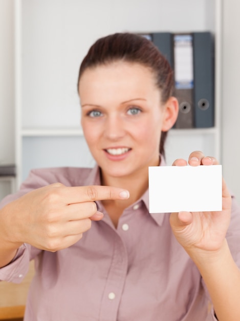 Photo femme d'affaires aux cheveux roux pointant sur une carte