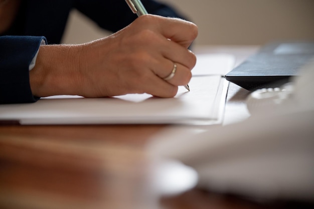 Femme d'affaires ou avocate caucasienne écrivant un rapport ou un document avec un stylo