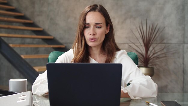 Femme d'affaires ayant un chat vidéo dans un bureau de luxe