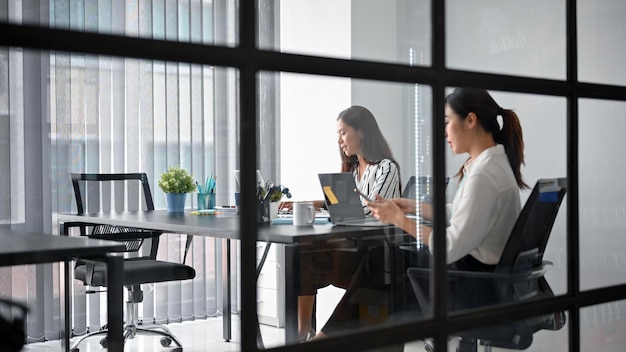 Femme d'affaires ayant une réunion avec un membre féminin du conseil d'administration. assistante consultant son patron dans la salle de réunion.