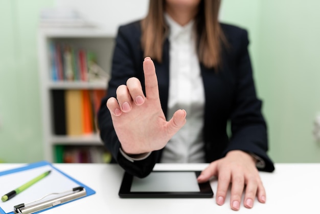 Femme d'affaires ayant une tablette sur le bureau et pointant des idées importantes avec un doigt