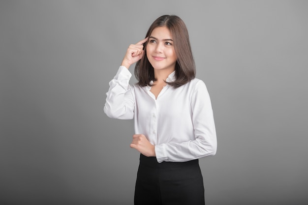 Femme d&#39;affaires belle pensée sur fond gris