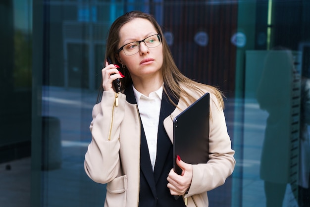 Une femme d'affaires belle et réussie d'origine ethnique caucasienne se tient debout et parle sur th