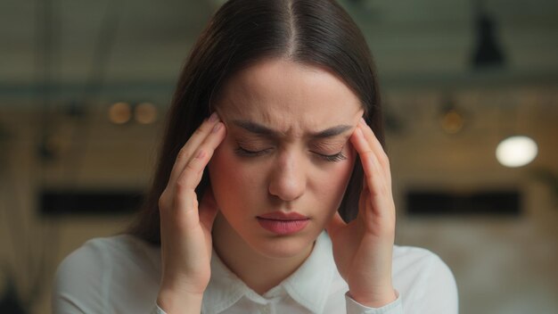 Femme d'affaires blanche femme d'affaires femme de bureau étudiante étudiant en ligne travail ordinateur portable se sent mal de tête souffre de migraines problème de santé stressé fille malade tension de la tête blessé douleur surtravail