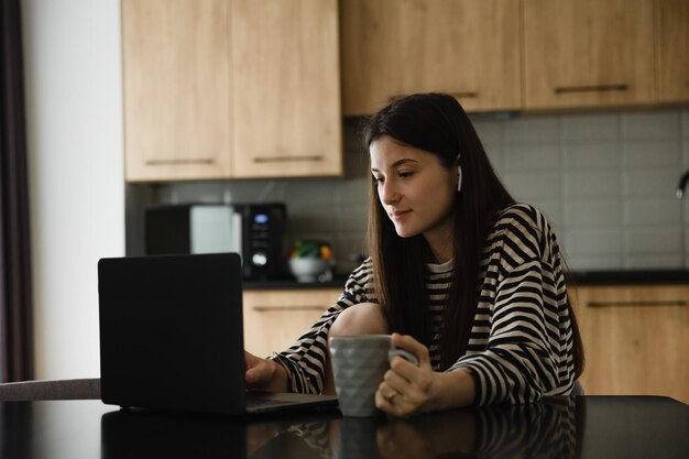 Femme d'affaires et blogueuse travaillant sur un ordinateur portable assis à la maison et gérant son entreprise via le bureau à domicile Espace de copie