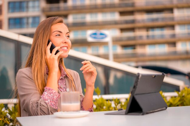 Femme D'affaires Blonde Exécutive Ayant Un Petit-déjeuner Au Café Décaféiné Lors D'un Appel De Travail