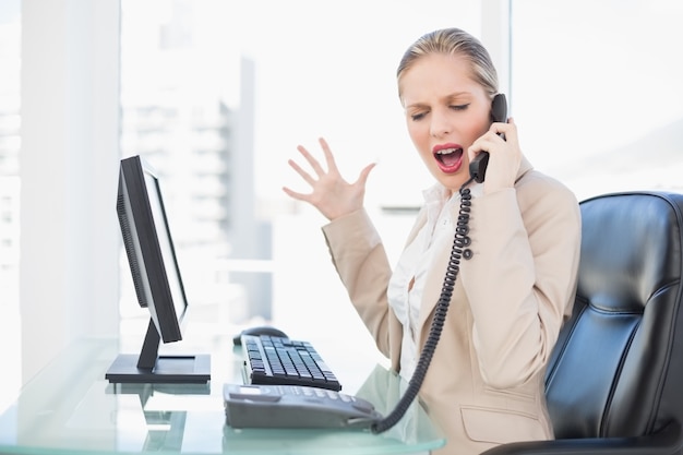 Femme d&#39;affaires blonde furieuse crier au téléphone