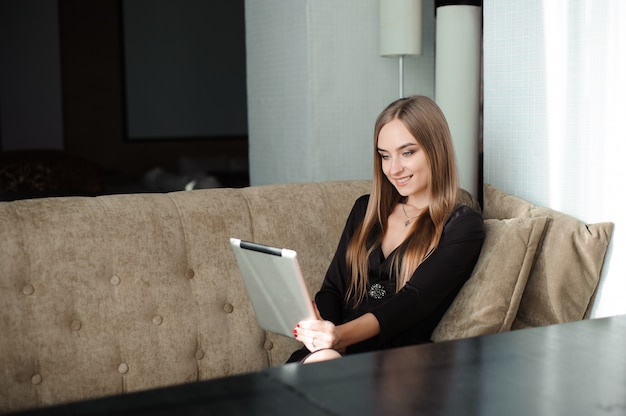 Femme d'affaires, boire du café, du thé dans un café à l'aide d'une tablette.