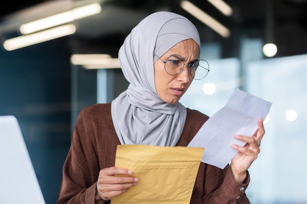 Femme d'affaires bouleversée en hijab travaillant à l'intérieur du bureau