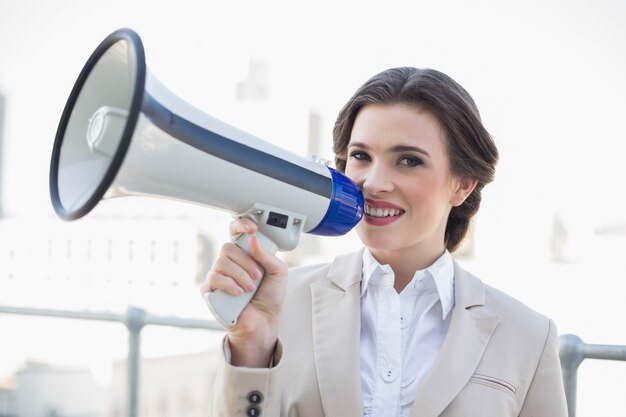 Femme d&#39;affaires brune assez élégante tenant un mégaphone