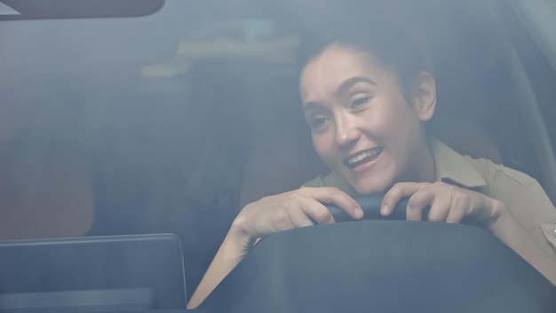 Femme d'affaires brune avec une expression ravie chante sa chanson préférée dans la voiture