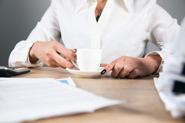 Femme d'affaires buvant du café au bureau.