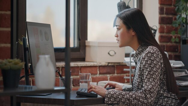 Femme d'affaires célébrant la réalisation du projet au bureau, se sentant satisfaite de la réussite. Employée appréciant la victoire et le succès pendant qu'elle travaille sur ordinateur au bureau.