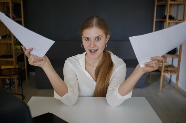 femme d'affaires en chemise blanche se réjouit de la tenue de feuilles blanches de documents papier