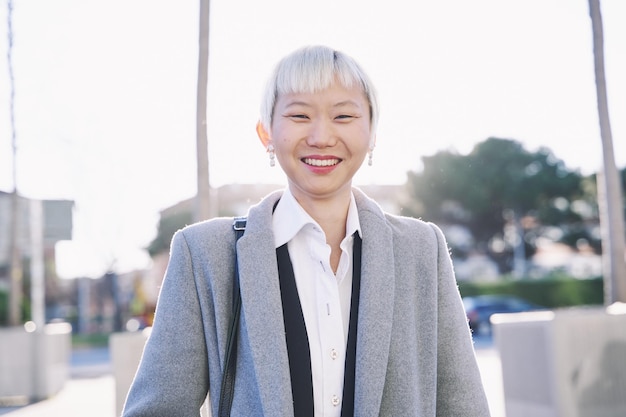 Femme d'affaires chinoise aux cheveux blancs courts tenue d'affaires souriant à la caméra