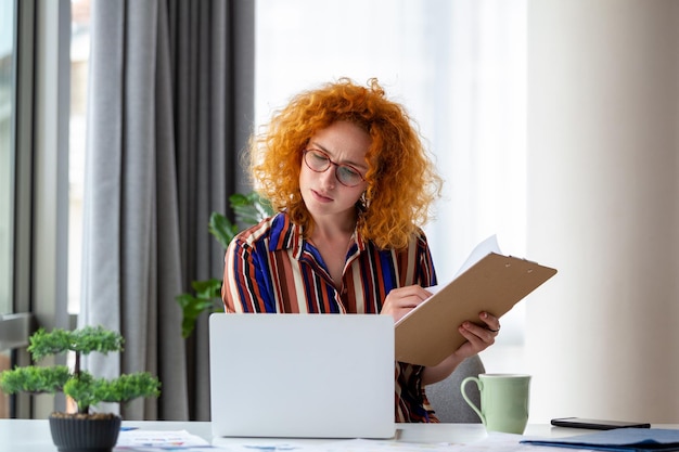 Femme d'affaires ciblée présentant des tableaux et des graphiques lors d'un appel vidéo en ligne Jeune femme d'affaires ayant une conférence téléphonique avec un client sur un ordinateur portable