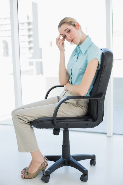 Femme d&#39;affaires classy épuisé, assis sur sa chaise pivotante