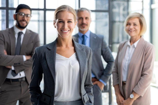 Femme d'affaires avec des collègues en arrière-plan au bureau