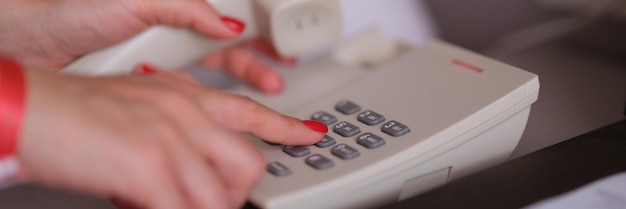 Femme d'affaires composant le numéro de téléphone dans la chambre d'hôtel