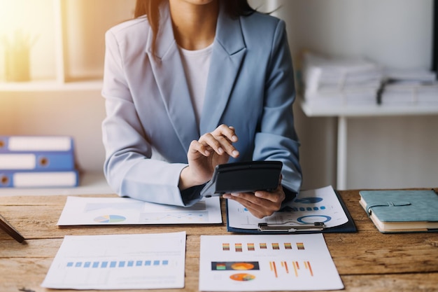 Femme d'affaires ou comptable travaillant Investissement financier sur calculatrice calculer analyser la croissance des affaires et du marketing sur le graphique de données de document financier Comptabilité Concept commercial économique