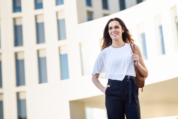 Femme d&#39;affaires confiant debout devant un immeuble de bureaux.