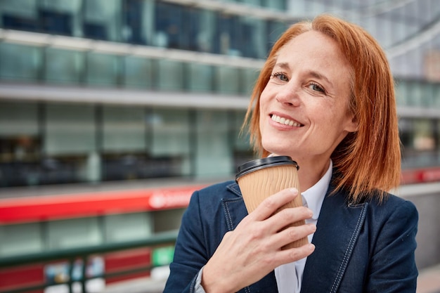 Une femme d'affaires confiante prend une pause avec un café qui gagne en énergie et en perspective