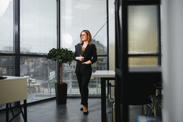 Femme d'affaires confiante se tient au bureau