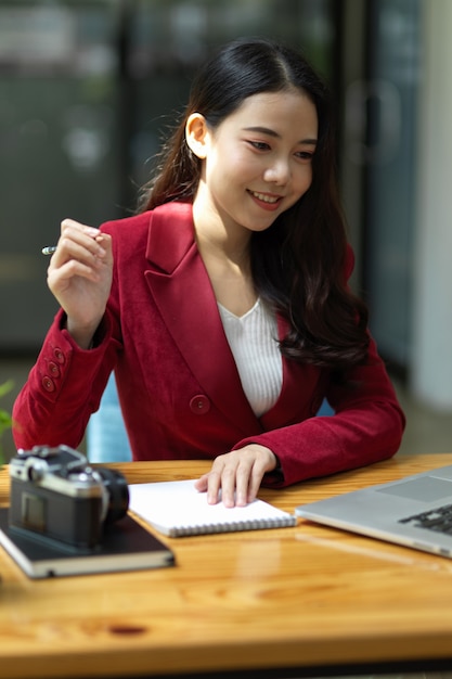 Femme d'affaires confiante travaillant à son bureau à la recherche d'un écran d'ordinateur portable