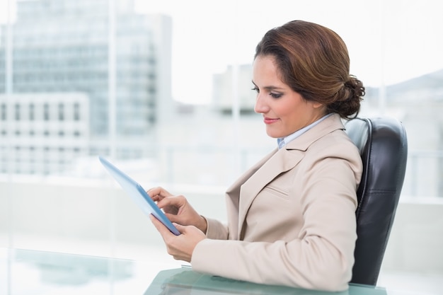 Femme d&#39;affaires de contenu en regardant la tablette