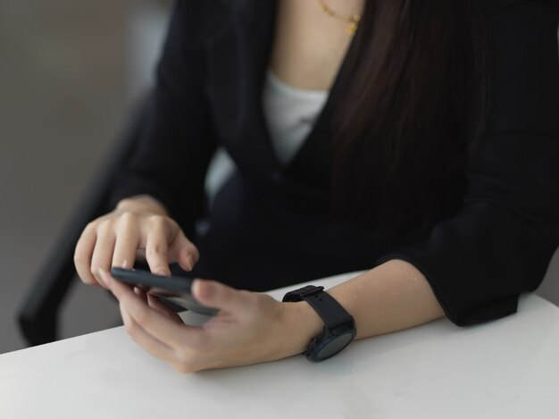 Femme d'affaires en costume à l'aide d'un smartphone