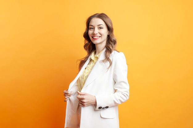 Femme d'affaires en costume blanc et blazer sur fond orange isolé