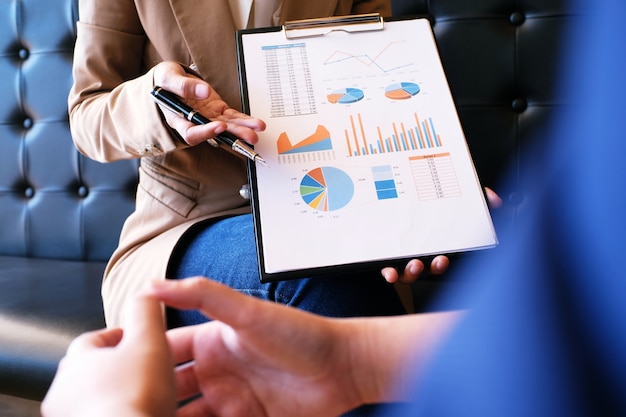 Femme d&#39;affaires en costume faisant une présentation expliquant les graphiques.