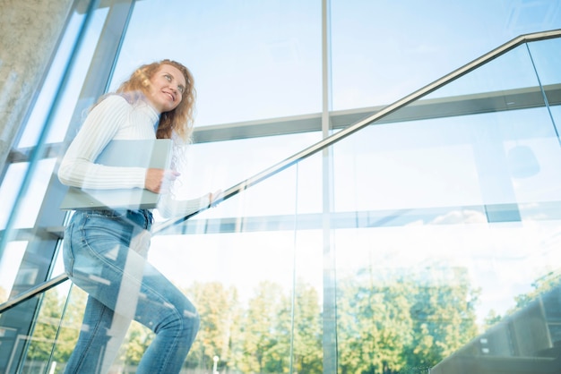 Photo femme d'affaires sur le côté en montant les escaliers