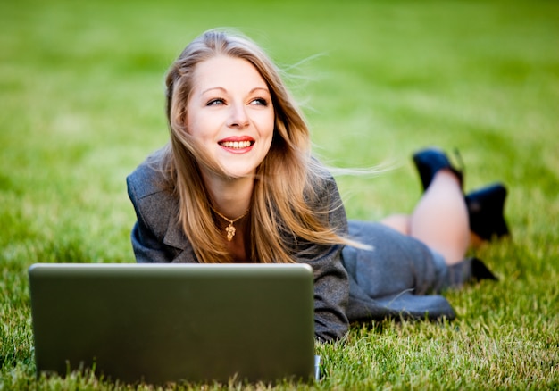 Femme affaires, coucher herbe, dans parc, à, cahier