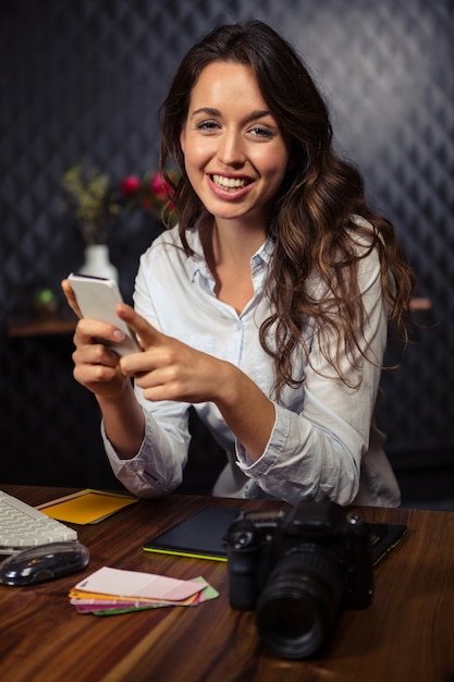 Femme d'affaires créative à l'aide de son smartphone