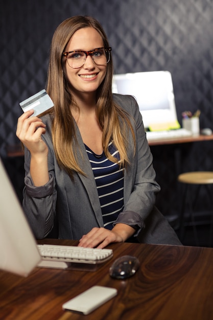 Femme d'affaires créative montrant une carte de crédit