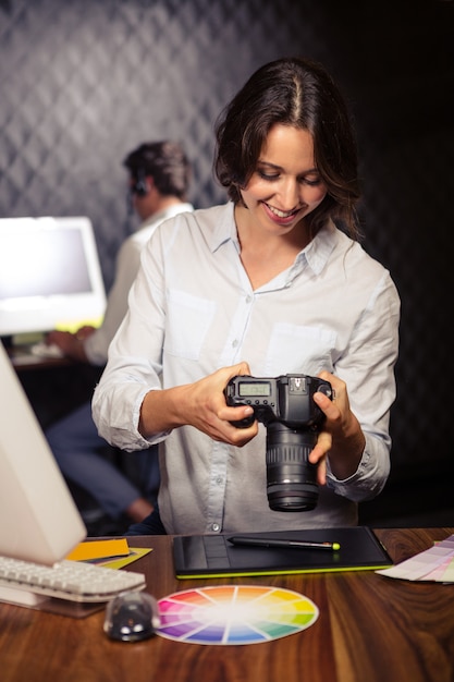 Femme d'affaires créative regardant des photos sur l'appareil photo